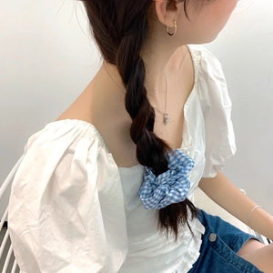 Chouchou à carreaux bleu et blanc sur une tresse pour un look doux et esthétique