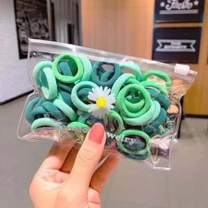 Green gradient daisy packaging hair ties set in a transparent zipper pouch