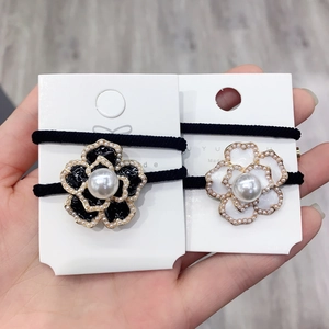 Detail of camellia hair rings with large central pearls and intricate bead-set petal edges