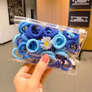 Close-up of blue elastic hair ties in a clear zipper bag with daisy floral pattern