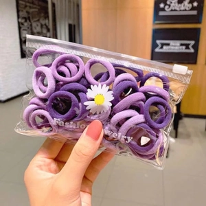 Detailed view of purple elastic hair ties set in a daisy transparent zipper pouch