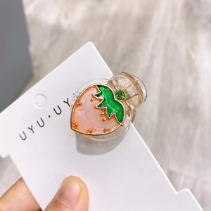 Gros plan d'une mini pince à cheveux fraise en résine rose avec strass brillant