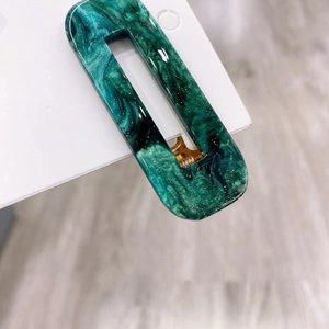 Elegant emerald green acetate rectangular hair clip with marble texture and gold glitter