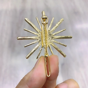 Golden snowflake hair clip with shiny starburst design and secure metal alligator grip