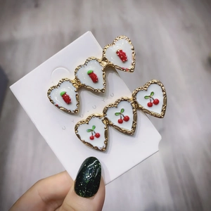 Set di due fermagli per capelli a forma di cuore con bordo dorato e motivi di ciliegie