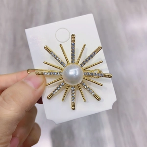 Detailed view of the sparkling sunburst hair clip with center pearl and crystal inlay