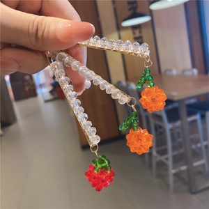 Detail of crystal beads and cute fruit charms on these golden metal hair clips for women