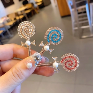Détail de barrettes sucettes avec strass, nœuds en ruban et perles brillantes
