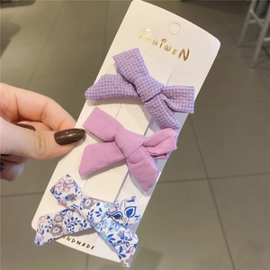 Set di tre fermagli per capelli con fiocco viola e motivi a quadri e floreali