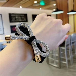 Sparkling rhinestone bow velvet hair tie in black with gold accents for women