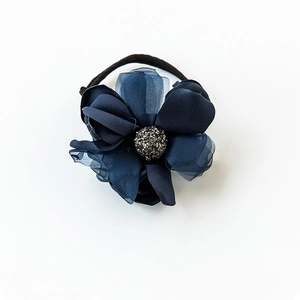 Détail d'un élastique à cheveux en satin bleu marine avec centre scintillant et mesh