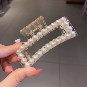 Close-up of a large square pearl hair claw clip with transparent acrylic and white pearls