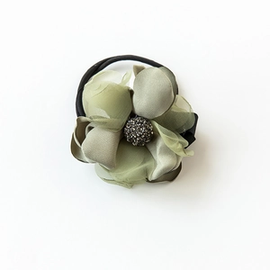 Détail d'un chouchou fleur vert olive avec strass scintillants et pétales en mesh léger
