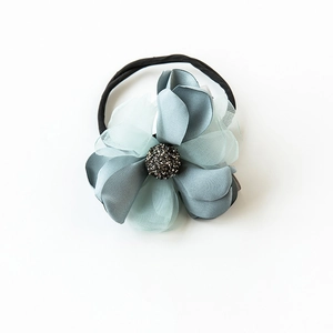 Détail d'un chouchou floral en soie gris-bleu et mesh avec des perles noires