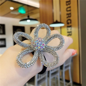 Elegant flower hair tie featuring sparkling crystals and a flexible black elastic band