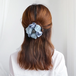 Accessoire cheveux fleur en maille bleue élégante porté par un modèle, style minimaliste