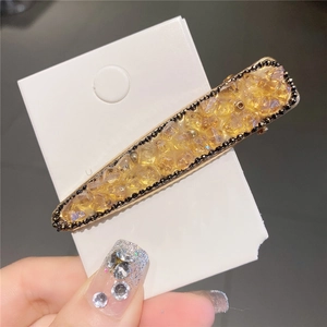 Détail de la pince à cheveux en cristal ambré avec bordure en perles noires
