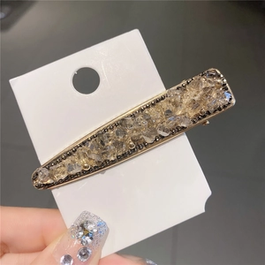 Barrette élégante avec cristaux de champagne et strass sur carte de présentation blanche