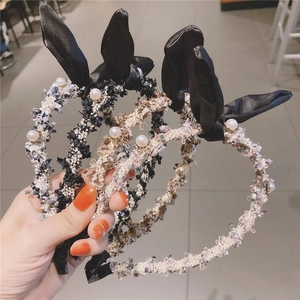 Detailed close-up of tweed headband with rabbit ears and embedded white pearls