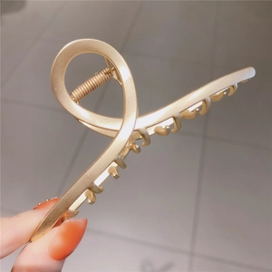 Minimalist matte gold metal hair claw clip with a stylish cross twist hollow out design