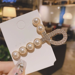 Détail de l'élégante barrette à cheveux en perles et strass brillants sur base dorée