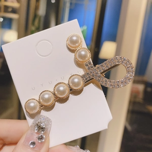 Pince à cheveux douce avec perles et nœud en cristal sur carte de présentation