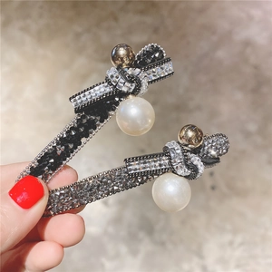 Lot de barrettes à nœud en cristal avec perles et strass présentées à la main
