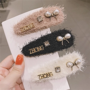 Detail of three-piece plush hair clips with faux fur, pearls, and rhinestones