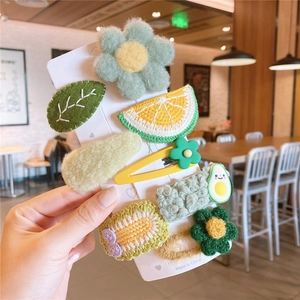 Detailed view of colorful plush floral and fruit cartoon hair clips for little girls