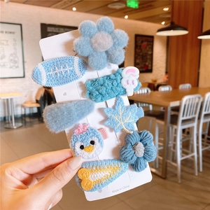 Detail showing an 8-piece blue handmade hair clips set with cute plush and knit designs
