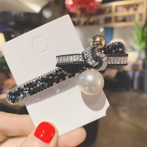 Barrette élégante avec cristaux et perles sur une carte de présentation blanche