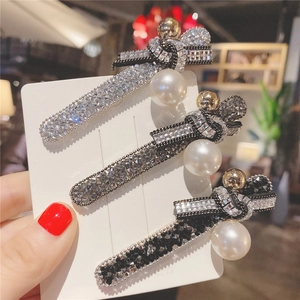Gros plan de barrettes à cheveux élégantes avec cristaux, perles et strass sur carte