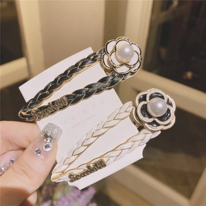 Elegant set of two camellia flower hair clips with leather texture and pearl detail