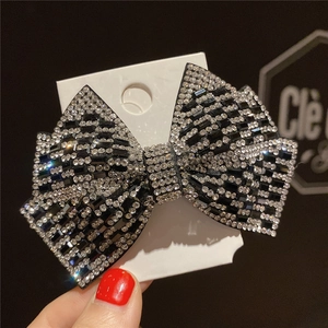 Bowknot hair claw clip with silver and black rhinestones on a display board