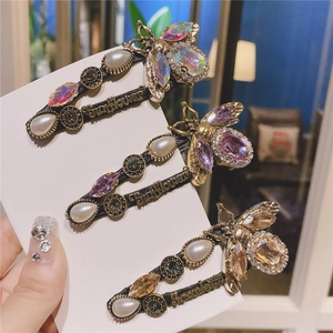 Detail of vintage gold hair clips with pearls, crystal rhinestones and bee ornaments