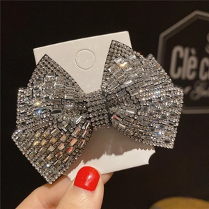 Close-up detail of a silver bow hair claw clip with shiny rhinestones and crystals