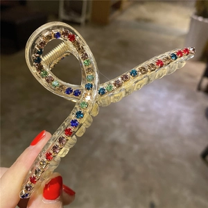 Dettaglio di un grande fermaglio per capelli con strass colorati e finitura acrilica
