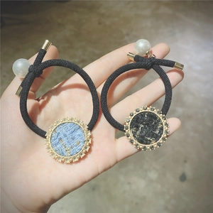 Close-up of elegant tweed hair ties with sparkling rhinestones and white pearl charms