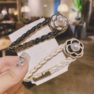 Detail of camellia pearl woven hair clips with metal base and leather texture finish