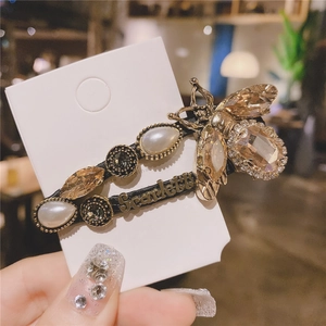 Detail of vintage honey bee hair clip featuring champagne crystals and white teardrop pearls