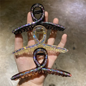 Dettaglio set di tre mollette per capelli in resina con strass colorati in nero e marrone