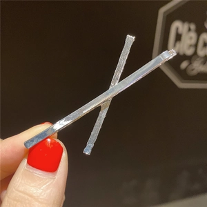 Pince à cheveux minimaliste en X argentée avec textures lisses et martelées
