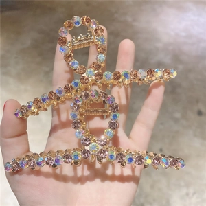 Pince à cheveux élégante en métal doré avec strass colorés au design géométrique croisé