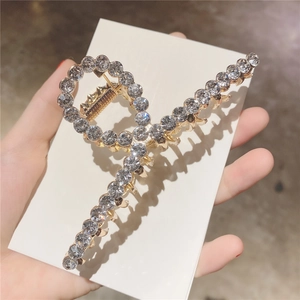 Détail de la pince à cheveux dorée ornée de strass brillants pour une coiffure élégante