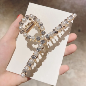 Détail d'une pince à cheveux dorée élégante avec perles et strass pour chignons