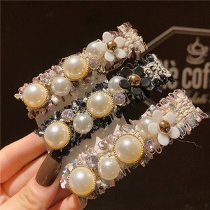 Gros plan sur d'élégantes barrettes en tweed avec perles et cristaux en trois couleurs