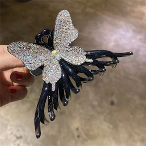 Détail d'une grande pince à cheveux noire ornée de strass colorés brillants effet AB
