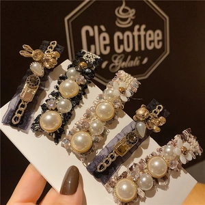 Gros plan de barrettes à fleurs élégantes avec perles et strass sur carte de support