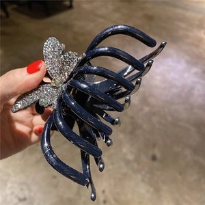 Pince à cheveux papillon ornée de strass brillants avec finition bleu marine