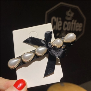 Elegant black satin bow hair clip with faux pearl detailing and gold metal edging